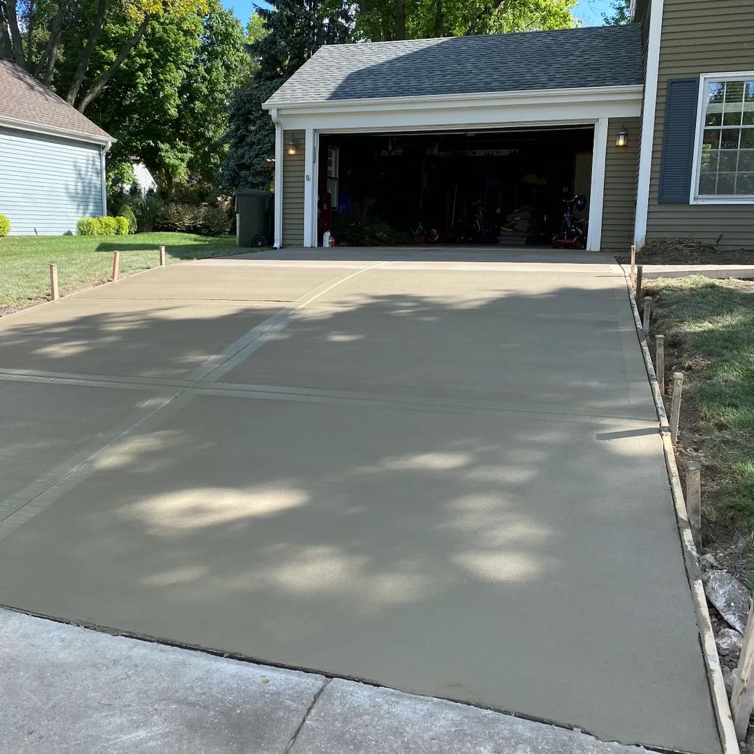 New concrete driveway in front of a two-car garage